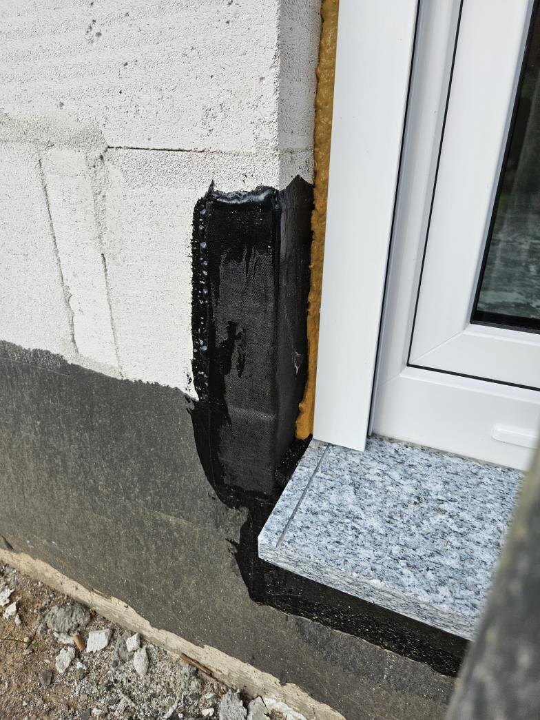 Fensteranschluss im Sockelbereich mit Bitumenabdichtung und Granitfensterbank